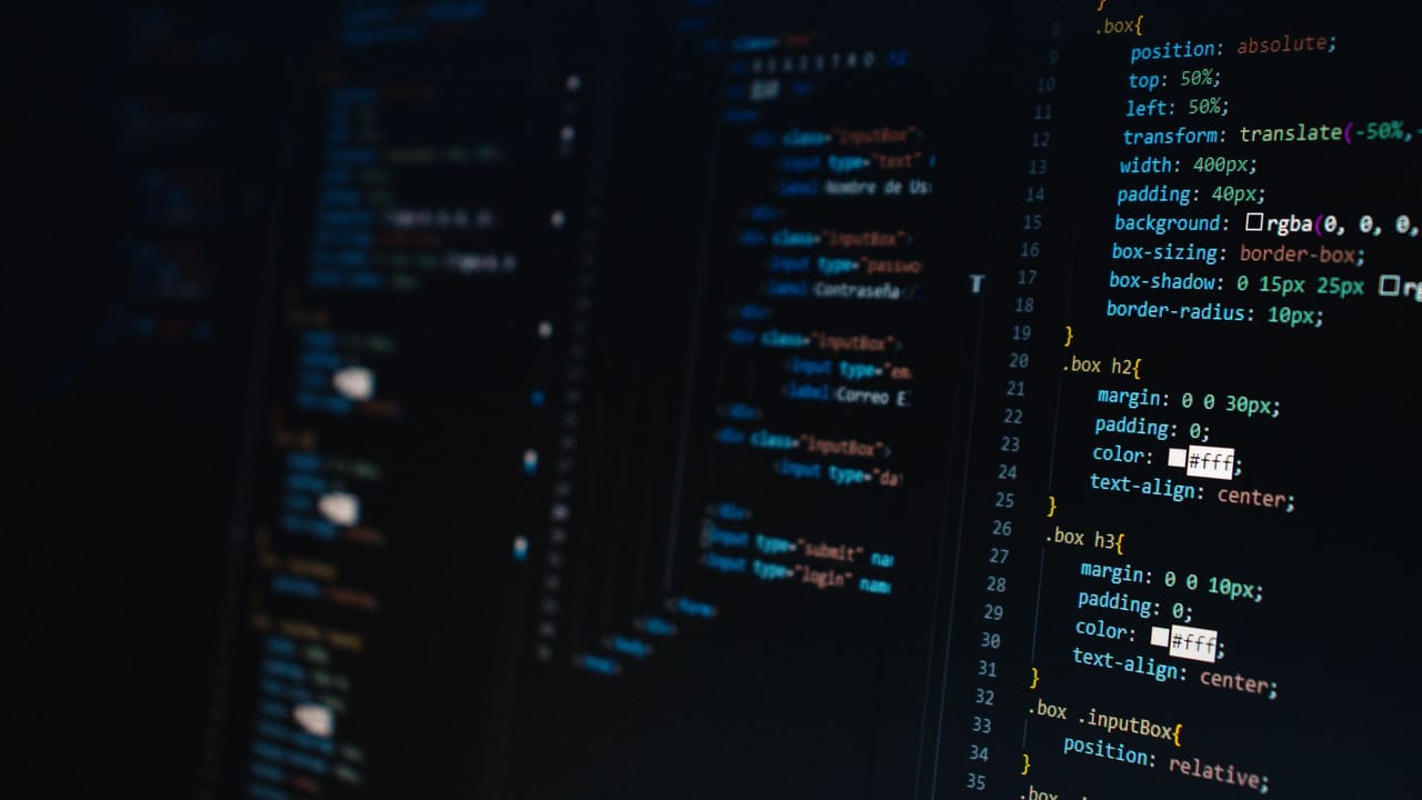 Código HTML e CSS numa tela escura, em close.