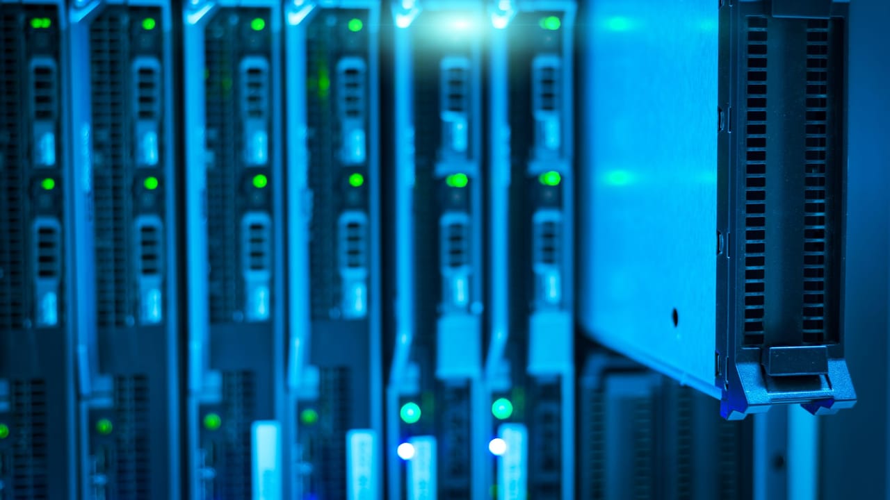 Racks de servidores num data center iluminado em azul.